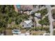 Overhead view of a property showcasing the house, pool, driveway, and surrounding greenery at 1320 Bayshore Dr, Englewood, FL 34223