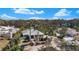 An elevated view of this home with a metal roof, blue shutters, and lush landscaping at 1320 Bayshore Dr, Englewood, FL 34223