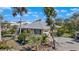 Attractive single-story home with a metal roof, blue shutters, mature trees, and a paved driveway at 1320 Bayshore Dr, Englewood, FL 34223