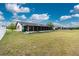 Expansive backyard view showcasing the home's screened lanai and spacious grassy area at 13360 Foresman Blvd, Port Charlotte, FL 33981