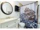 Inviting bathroom featuring a stylish ship-themed shower curtain, round mirror, and granite countertop at 13360 Foresman Blvd, Port Charlotte, FL 33981
