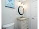 Bathroom featuring a granite-topped vanity, round mirror, and modern three-bulb lighting at 13360 Foresman Blvd, Port Charlotte, FL 33981