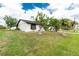 Landscaped yard of well-maintained single-story home featuring mature trees and lush green grass at 13360 Foresman Blvd, Port Charlotte, FL 33981