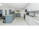 Spacious kitchen featuring white cabinets, granite countertops, stainless steel appliances, and a gray kitchen island at 13360 Foresman Blvd, Port Charlotte, FL 33981