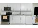 Modern kitchen featuring white cabinets, granite countertops, stainless steel appliances, and tile backsplash at 13360 Foresman Blvd, Port Charlotte, FL 33981