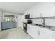 Modern kitchen featuring white cabinets, granite countertops, stainless steel appliances, and tile floors at 13360 Foresman Blvd, Port Charlotte, FL 33981