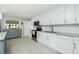 Bright kitchen featuring white cabinets, granite countertops, stainless steel appliances, and tile floors at 13360 Foresman Blvd, Port Charlotte, FL 33981