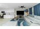Bright living room offers a modern design with a gray sectional, updated cabinets, and a stylish blue rug at 13360 Foresman Blvd, Port Charlotte, FL 33981