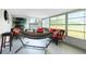 Bright sunroom with a hammock, lounge chairs, and a lovely view of the surrounding landscape at 13360 Foresman Blvd, Port Charlotte, FL 33981
