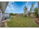 Spacious backyard with lush green grass, mature landscaping, and outdoor seating area at 13559 Martha Ave, Port Charlotte, FL 33981