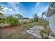Spacious backyard with mature landscaping, brick fire pit, and a blue sky at 13559 Martha Ave, Port Charlotte, FL 33981