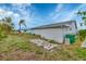 Spacious backyard featuring mature palm trees, lush green grass, and a storage shed at 13559 Martha Ave, Port Charlotte, FL 33981