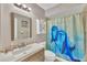 Bathroom with a wooden vanity, mosaic backsplash, matching mirror, and a dolphin shower curtain at 13559 Martha Ave, Port Charlotte, FL 33981