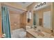 Tiled bathroom with a shower-tub combo, vanity, and ample storage space, offering a functional and stylish design at 13559 Martha Ave, Port Charlotte, FL 33981
