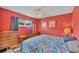 Vibrant bedroom with red walls, bright accents, and a comfortable bed, providing a cozy and inviting atmosphere at 13559 Martha Ave, Port Charlotte, FL 33981