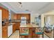 Spacious kitchen featuring wood cabinets, a breakfast bar, and tiled flooring leading into a sunlit dining area at 13559 Martha Ave, Port Charlotte, FL 33981