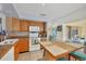 Well-lit kitchen with a breakfast bar, wooden cabinetry, and access to a dining area filled with natural light at 13559 Martha Ave, Port Charlotte, FL 33981