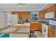 Well-lit kitchen featuring tile countertops, a center island with seating and a full appliance suite at 13559 Martha Ave, Port Charlotte, FL 33981