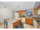 Bright kitchen with a breakfast bar, wooden cabinets, and tiled floors, offering a cozy space for meal preparation at 13559 Martha Ave, Port Charlotte, FL 33981