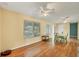 Sun-drenched living room with hardwood floors, multiple windows, and ceiling fans, creating a bright and welcoming atmosphere at 13559 Martha Ave, Port Charlotte, FL 33981