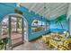 Inviting porch with ample seating, ceiling fan, a vibrant wall mural and scenic neighborhood views at 13559 Martha Ave, Port Charlotte, FL 33981
