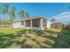 View of the home's backyard showing the screened lanai, a fenced yard, and lush grass at 14795 San Domingo Blvd, Port Charlotte, FL 33981