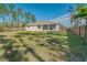 A large, well-maintained backyard featuring a home with a screened lanai and a wood fence at 14795 San Domingo Blvd, Port Charlotte, FL 33981