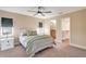 Bright bedroom features a ceiling fan, bedside tables, and an ensuite bathroom with walk-in closet at 14795 San Domingo Blvd, Port Charlotte, FL 33981