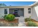 Inviting screened front porch, with a cozy seating area and well-maintained landscaping at 14795 San Domingo Blvd, Port Charlotte, FL 33981