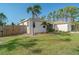 Lush green yard featuring mature palm trees and a charming wooden privacy fence at 14795 San Domingo Blvd, Port Charlotte, FL 33981