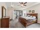 A bright and airy main bedroom offers a tray ceiling and sliding glass door to the outdoor patio at 15180 Alsask Cir, Port Charlotte, FL 33981