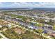 An aerial view of a charming residential neighborhood featuring canal-front homes and lush greenery at 15776 Melport Cir, Port Charlotte, FL 33981