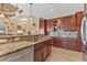 Well-appointed kitchen with wood cabinets, granite counters, tile backsplash, and modern stainless steel appliances at 15776 Melport Cir, Port Charlotte, FL 33981