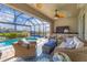 Outdoor covered patio features wicker seating, a tv, and a clear view of the pool and canal at 15776 Melport Cir, Port Charlotte, FL 33981