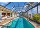 Relaxing screened-in pool with an attached lanai and outdoor seating area at 15776 Melport Cir, Port Charlotte, FL 33981