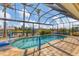 Refreshing screened-in pool area with blue handrail and basketball hoop offers an ideal spot for outdoor fun at 15776 Melport Cir, Port Charlotte, FL 33981