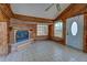 Living area featuring wood paneled walls, tile floors, vaulted ceilings, fireplace, and a glass front door at 160 W Bay St, Englewood, FL 34223