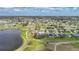 Aerial view of a charming neighborhood with a lake, golf course, and beautiful homes with inviting landscapes at 18 Pebble Beach Road, Rotonda West, FL 33947