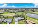 Expansive aerial view of neighborhood homes surrounding a lush green golf course and pond on a sunny day at 18 Pebble Beach Road, Rotonda West, FL 33947