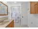 Bathroom featuring neutral tile floors, wooden vanity, and bath-shower combo at 18 Pebble Beach Road, Rotonda West, FL 33947