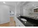 Well-lit bathroom with black granite vanity, white cabinets, and tiled shower-tub at 18 Pebble Beach Road, Rotonda West, FL 33947