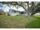 Beautiful home exterior features a lush green lawn, mature trees, and a screened patio for outdoor enjoyment at 18 Pebble Beach Road, Rotonda West, FL 33947