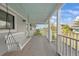 Welcoming front porch featuring a swing and offering a glimpse of the surrounding greenery at 18 Pebble Beach Road, Rotonda West, FL 33947