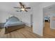 A spacious main bedroom with a ceiling fan and access to the en-suite bathroom at 18 Pebble Beach Road, Rotonda West, FL 33947