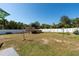 Large backyard featuring a wooden platform, white fence, and beautiful landscaping at 18970 Mcgrath Cir, Port Charlotte, FL 33948