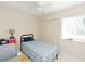 Cozy bedroom featuring a twin bed, ceiling fan, tile flooring, and closet for storage at 18970 Mcgrath Cir, Port Charlotte, FL 33948