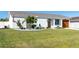 Charming single-story home with manicured lawn, lovely flower bed, and attached garage at 18970 Mcgrath Cir, Port Charlotte, FL 33948