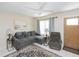 Cozy living room with comfortable seating, a ceiling fan, and a bright window with curtains at 18970 Mcgrath Cir, Port Charlotte, FL 33948