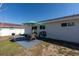Back patio offers open-air dining with a table, chairs, umbrella, grill, and a view of the fenced backyard at 18970 Mcgrath Cir, Port Charlotte, FL 33948