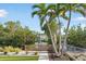 Beautifully landscaped backyard with tropical palm trees, lawn, and waterfront access at 205 Sand Dollar Ln, Englewood, FL 34223